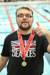 Man giving thumbs up wearing a medal around his neck