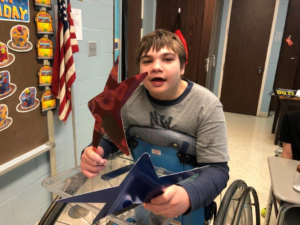 Boy in wheelchair holding red and blue star